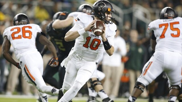 Oklahoma State Cowboys quarterback Mason Rudolph (10) rolls out to pass in the second quarter against the Baylor Bears at McLane Stadium. 