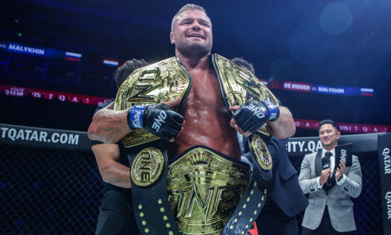 Anatoly Malylhin holding three belts