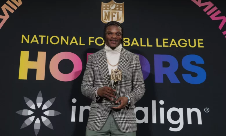 Lamar Jackson holding the NFL MVP trophy for 2023